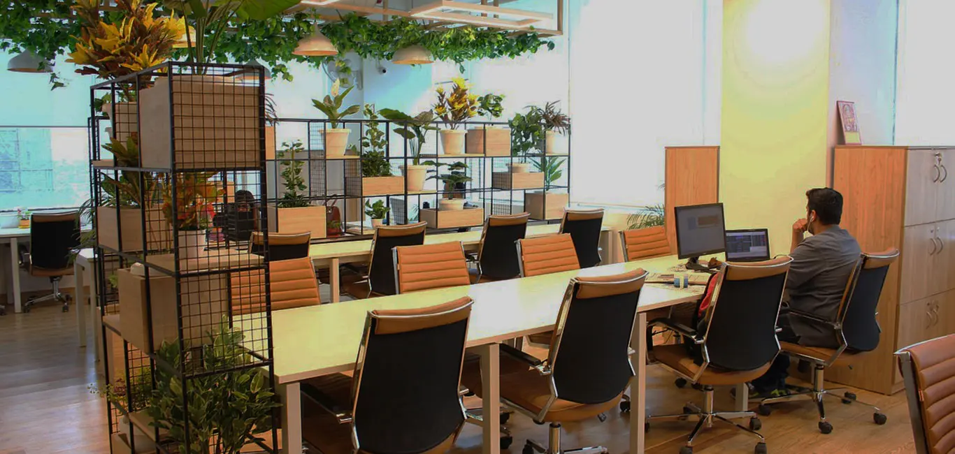 A large coworking space with plants and desks