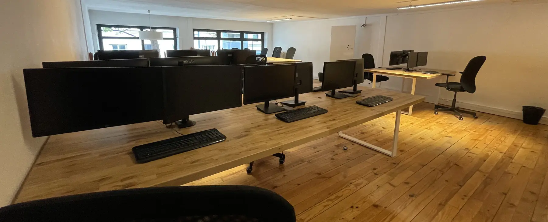Open-plan desks with two screens at Panda Coworking