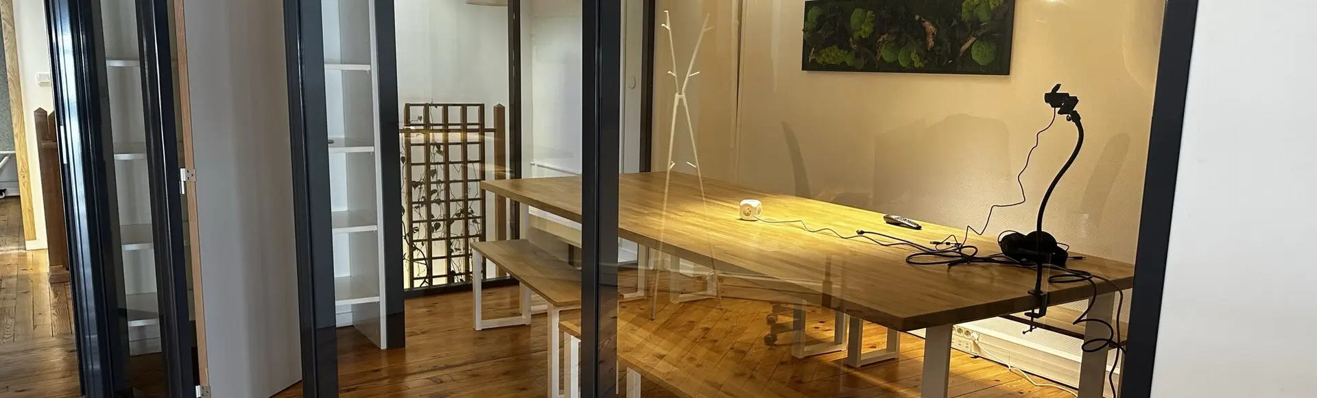 Panda Coworking meeting room: large wooden table and plant wall